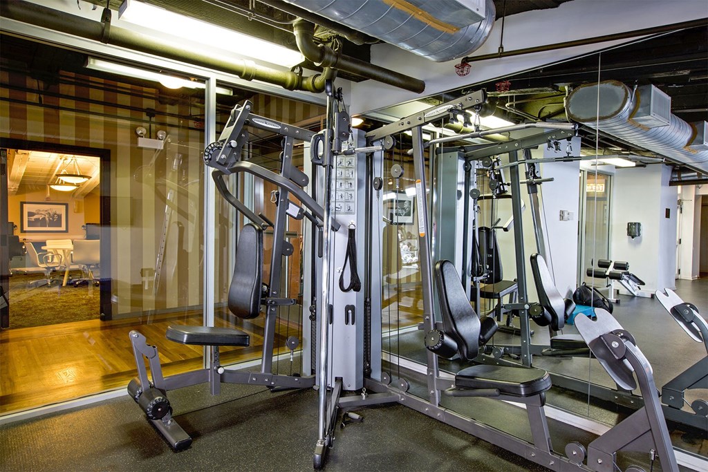 a gym with weights and cardio equipment in a building