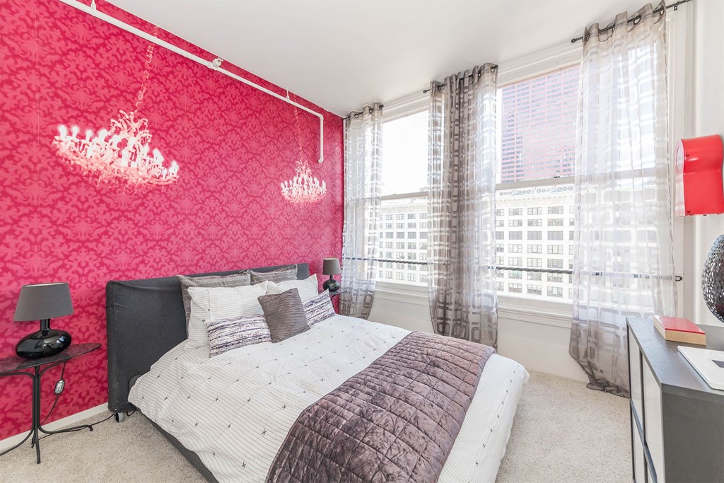 a bedroom with a bed and a red wall