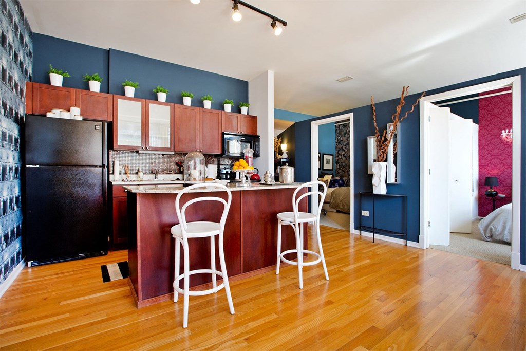 a kitchen and living room with a bar and a refrigerator