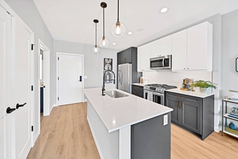 A kitchen with a white counter top and black cabinets.