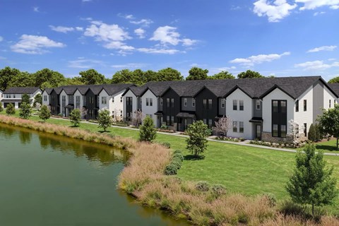 A row of houses with a body of water in front.