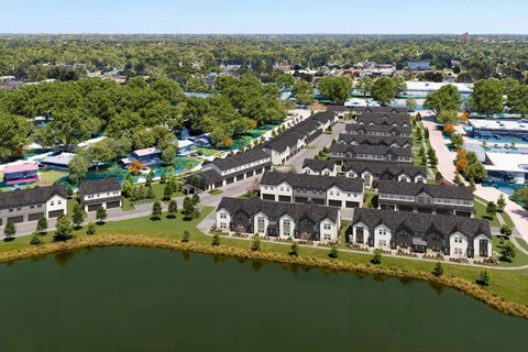 A large body of water is in the foreground of a residential area.