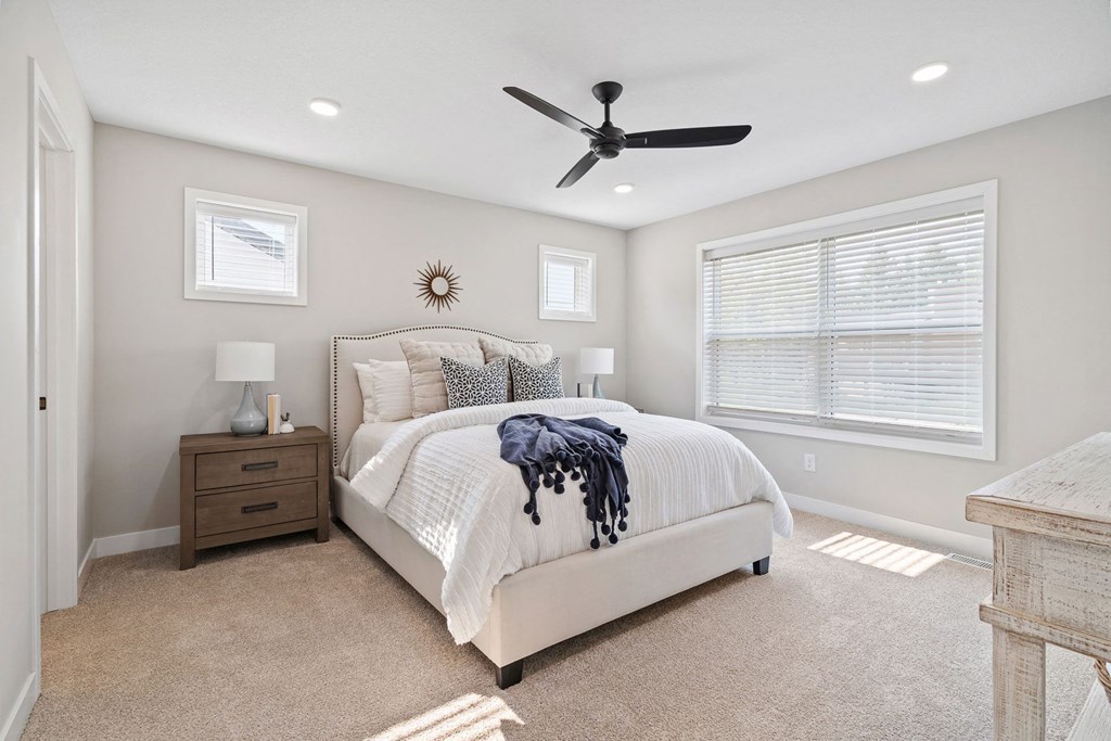 a bedroom with a bed and a ceiling fan