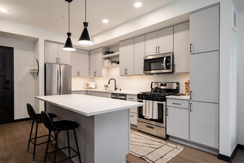 a kitchen with white cabinets and stainless steel appliances