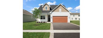 A two-story house with a garage door and a driveway.