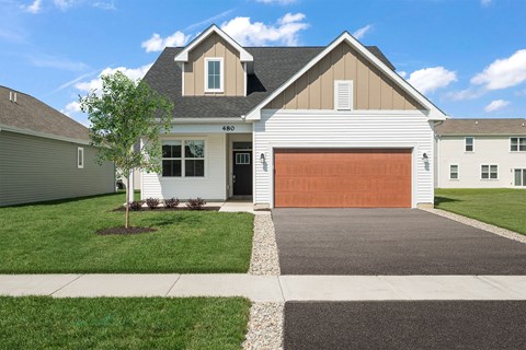 A two-story house with a garage door and a driveway.