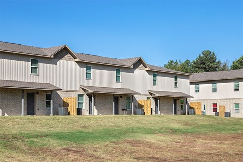 A row of houses with a grassy field in front.