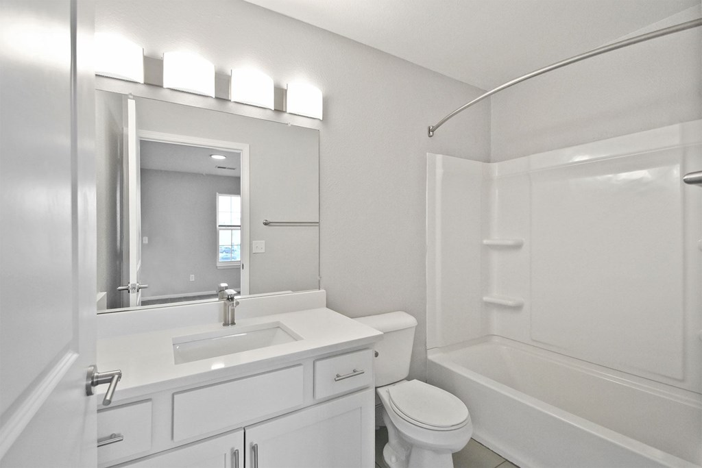 A white bathroom with a sink, toilet, and bathtub.