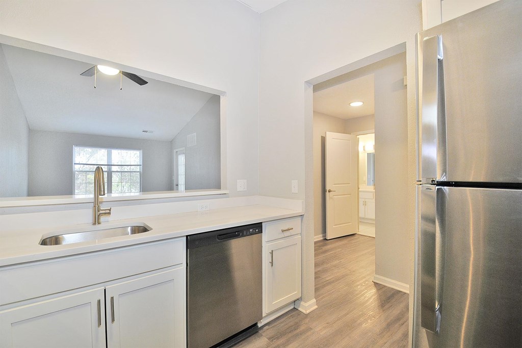 A modern kitchen with white cabinets and a stainless steel refrigerator.