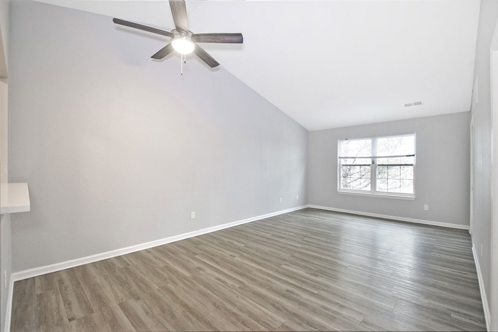 A room with a ceiling fan and a window.