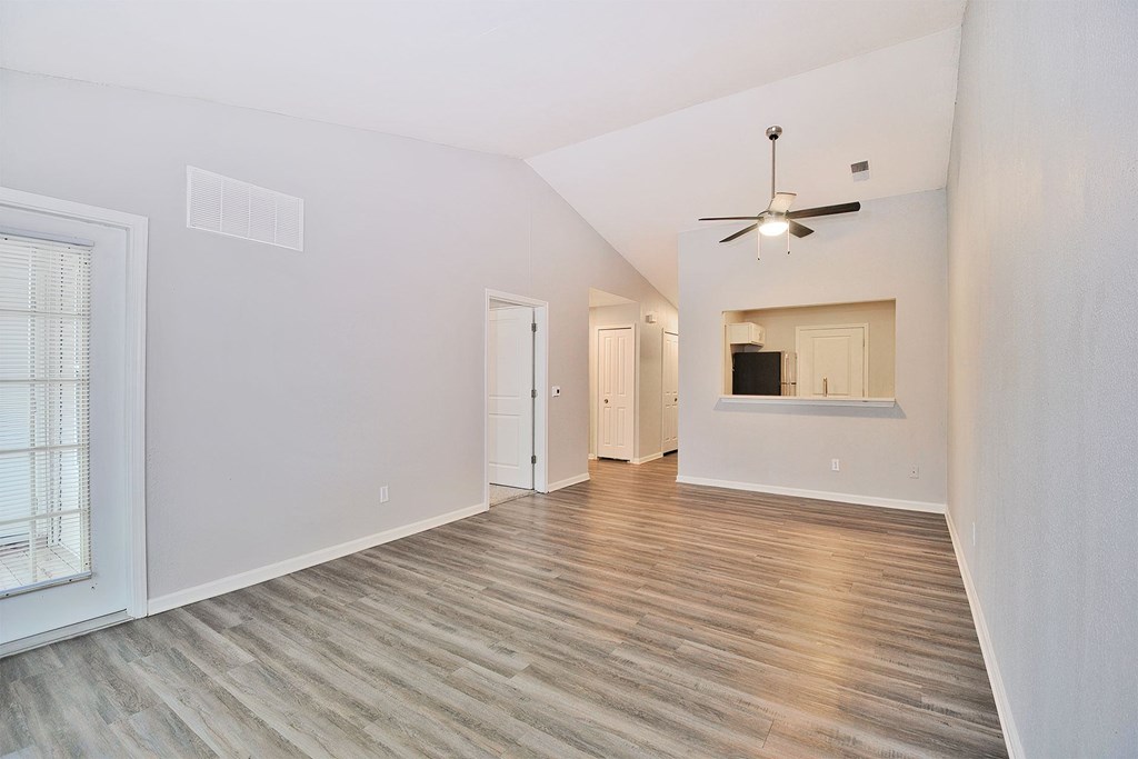 A room with a ceiling fan and a window with blinds.