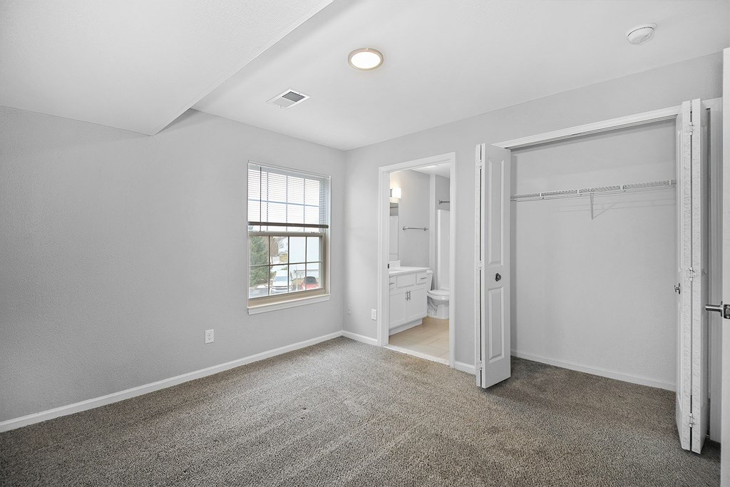 A room with a carpeted floor and a window.
