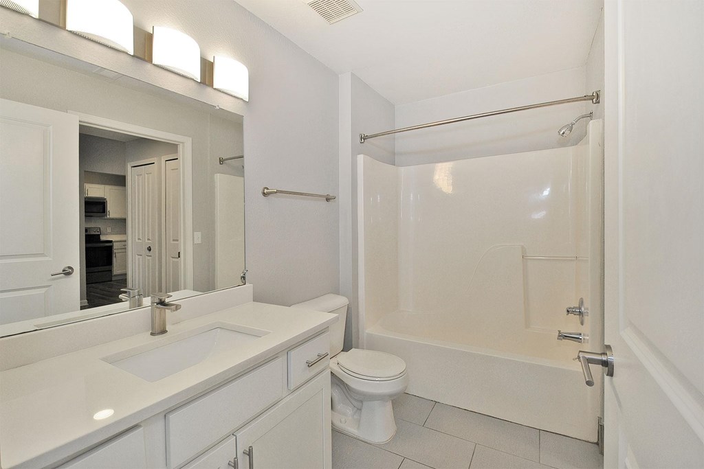 A white bathroom with a toilet, sink, and bathtub.