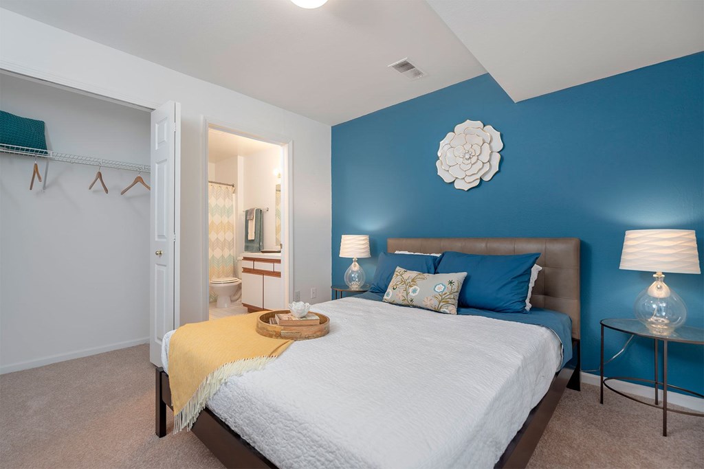 A bedroom with a white bed and a blue wall.