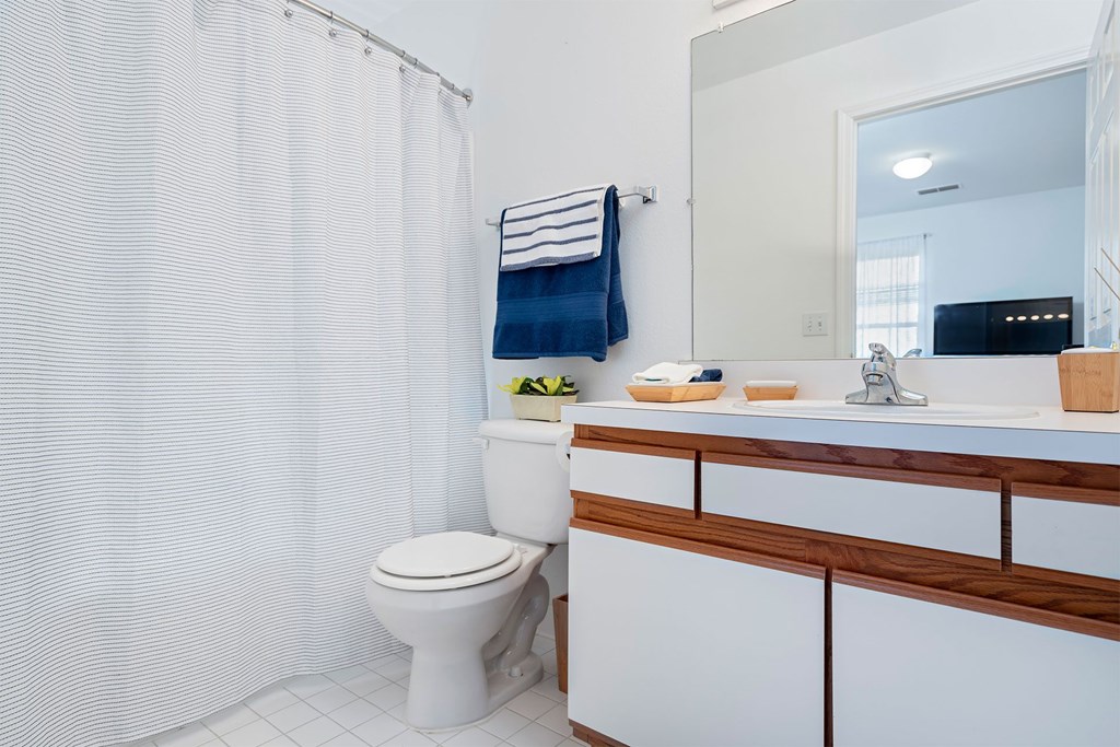 A white toilet sits next to a white sink in a bathroom.