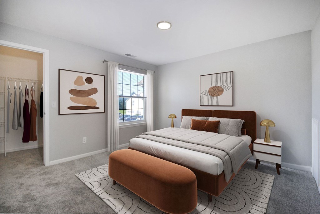 A bedroom with a large bed and two framed artworks on the wall.