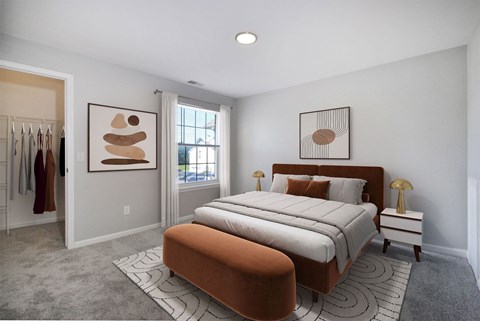 A bedroom with a large bed and two framed artworks on the wall.
