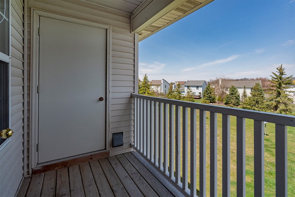 A white door is on the porch of a house.