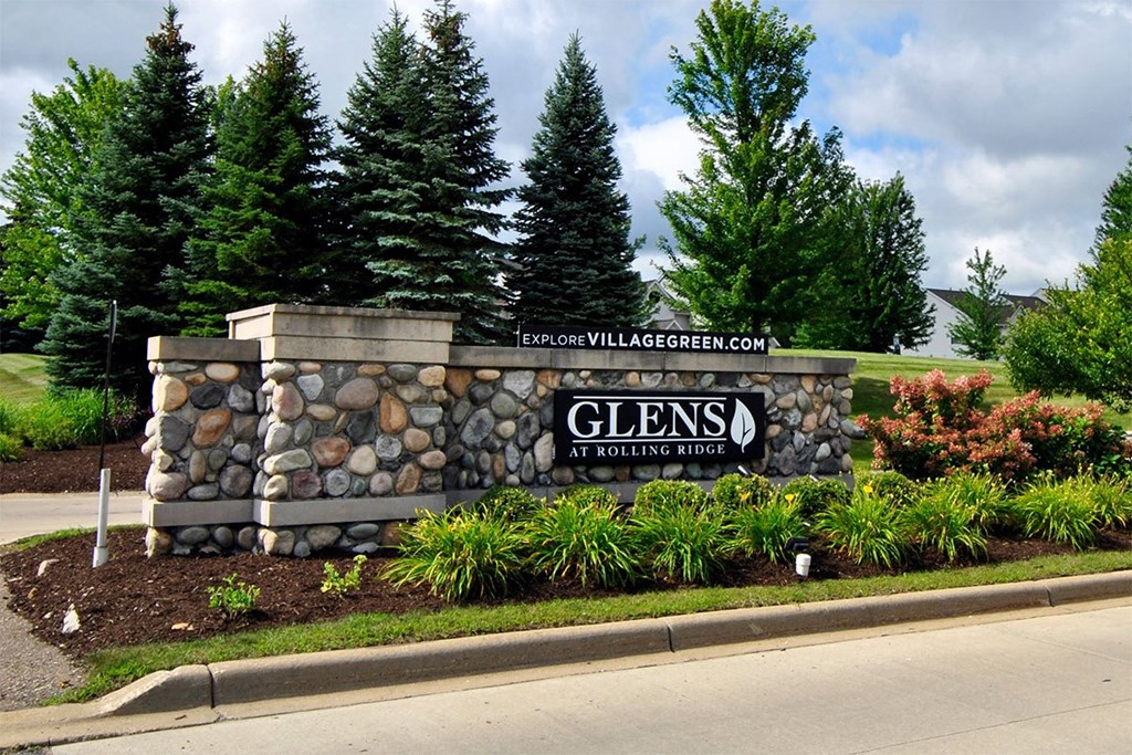 A stone pillar with a sign that says Glens at Rolling Ridge.