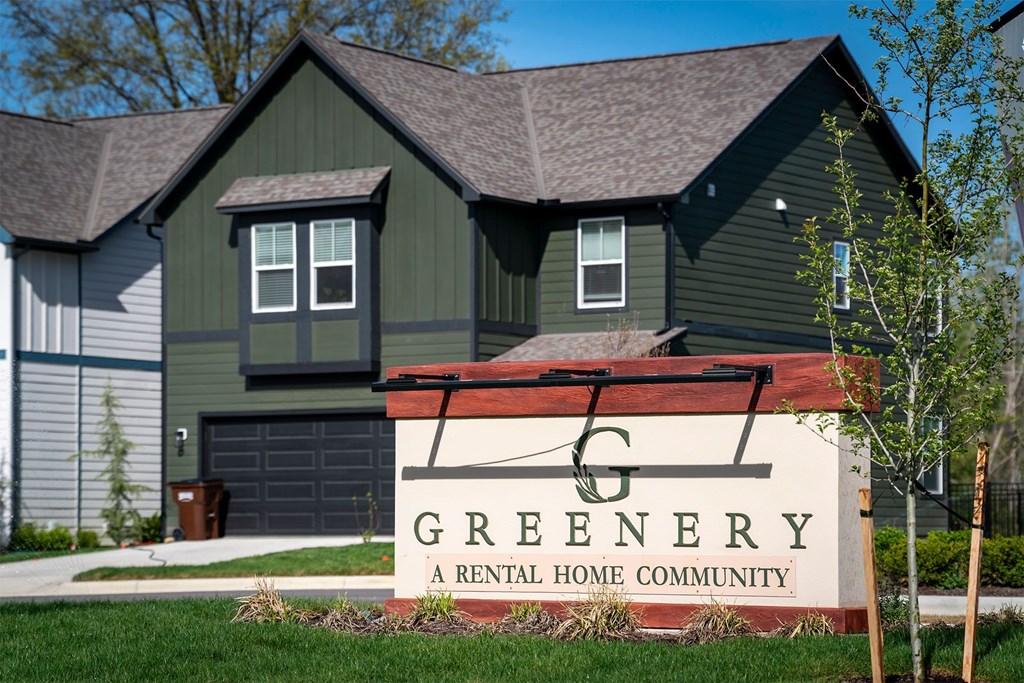 A sign that says Greenery in front of a house.