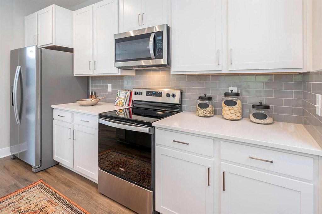 a kitchen with white cabinets and stainless steel appliances