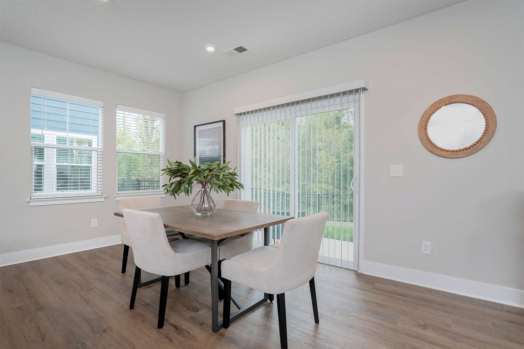 a dining room with a table and chairs and a window