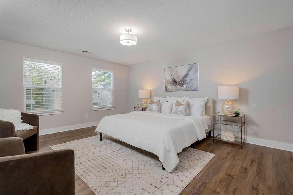 a white bedroom with a bed and a couch