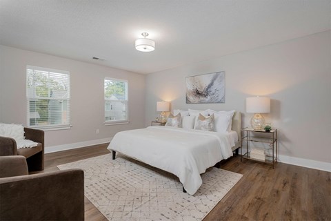 a white bedroom with a bed and a couch