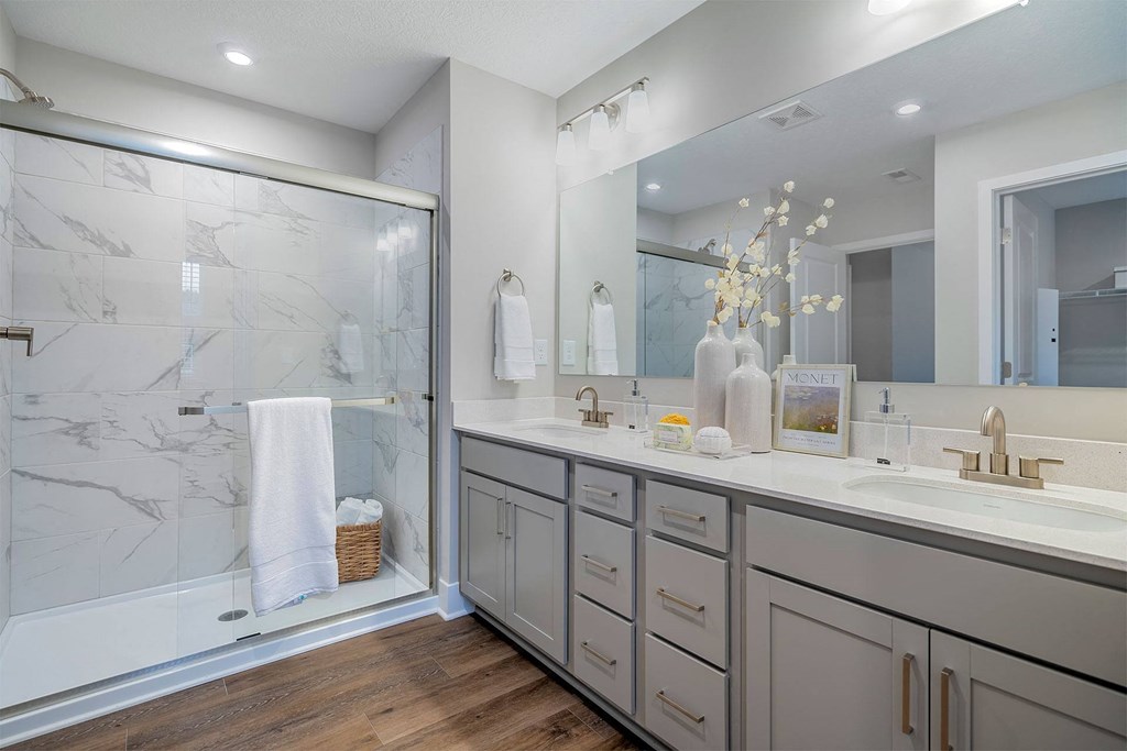 bathroom with dual vanity and standing shower