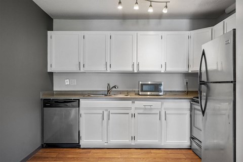 A kitchen with white cabinets and appliances.