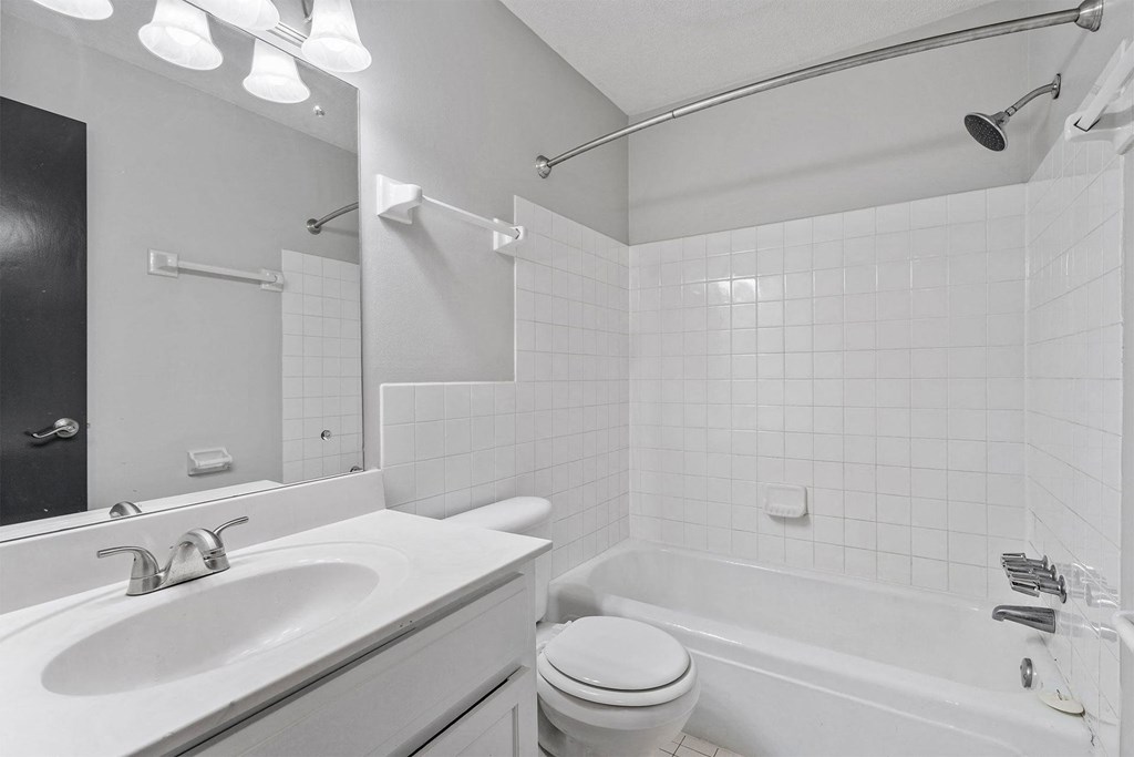 A white bathroom with a sink, toilet, and bathtub.