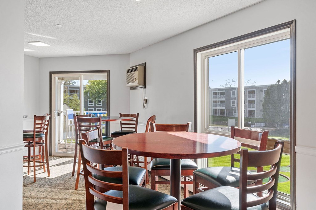 A dining room with a round table and chairs.