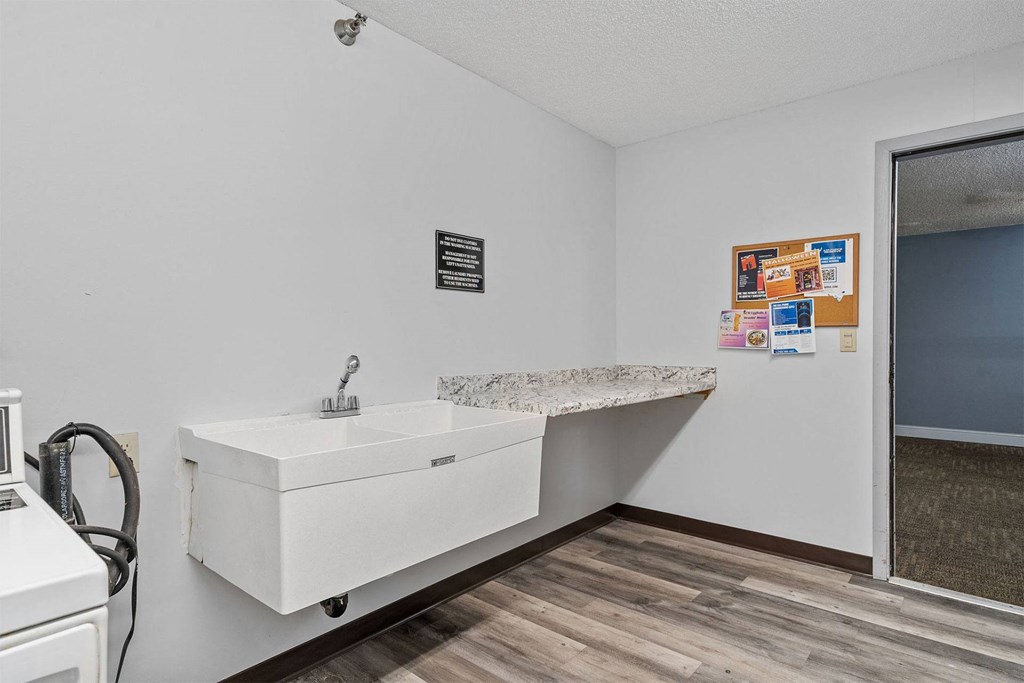 A white bathroom sink with a marble countertop and a white toilet.