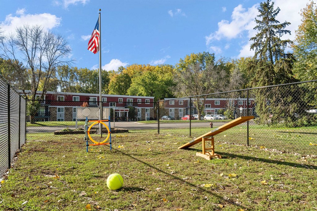 A playground with a yellow ball and a seesaw.