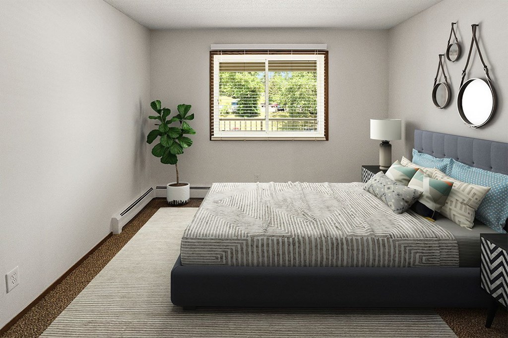 A bedroom with a large bed and a window with blinds.