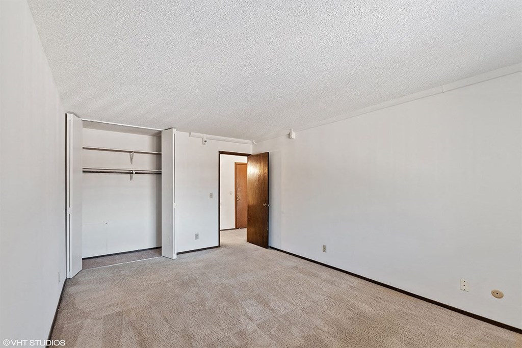 Empty room with a carpeted floor and white walls.