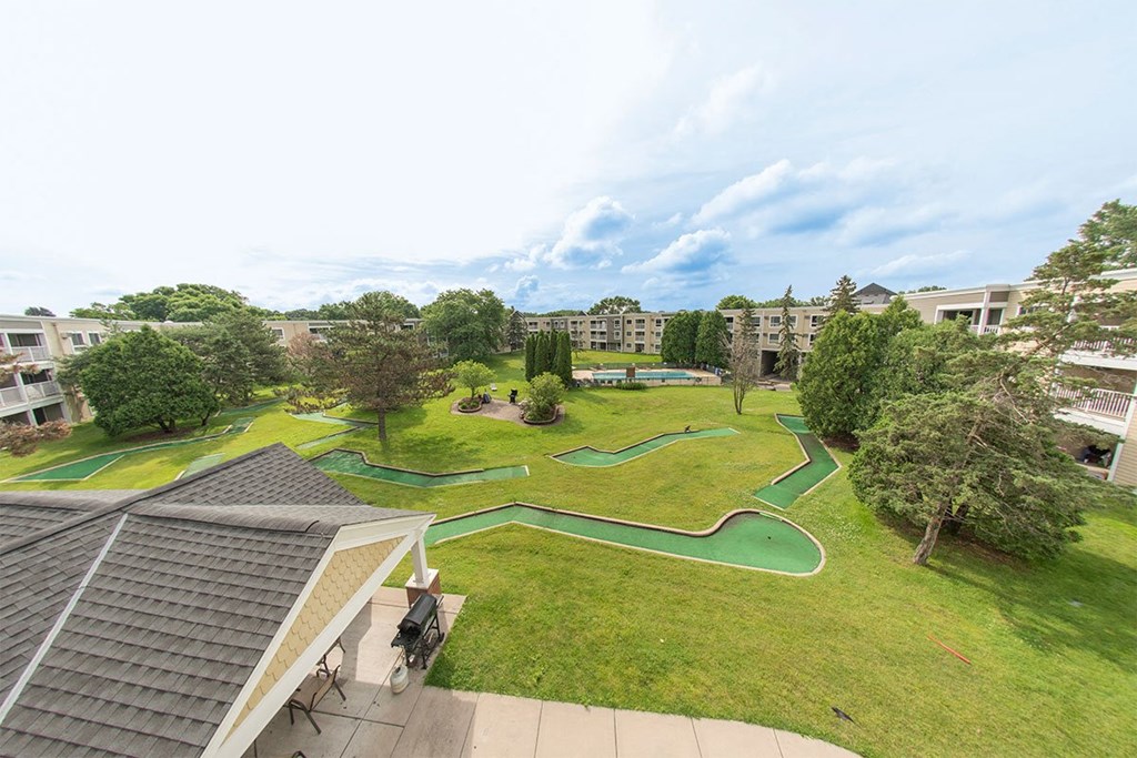 A green lawn with a pathway and a building in the background.
