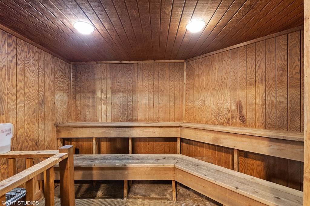 A wooden room with a bed in the middle.