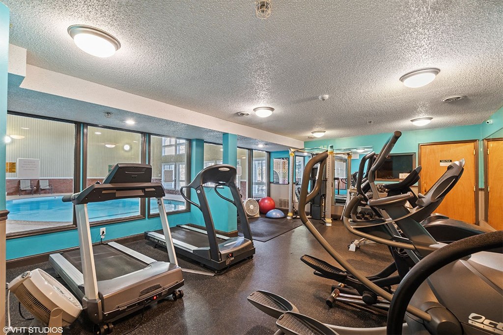 A gym with treadmills, exercise bikes, and other equipment.