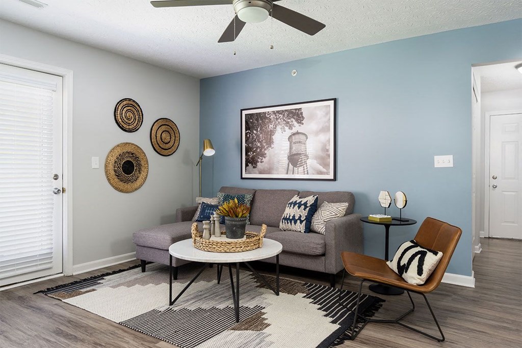 A living room with a grey couch, a coffee table, and a chair.