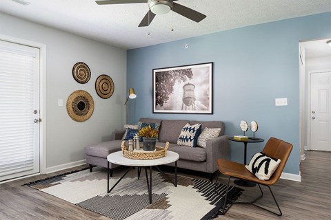 A living room with a grey couch, a coffee table, and a chair.