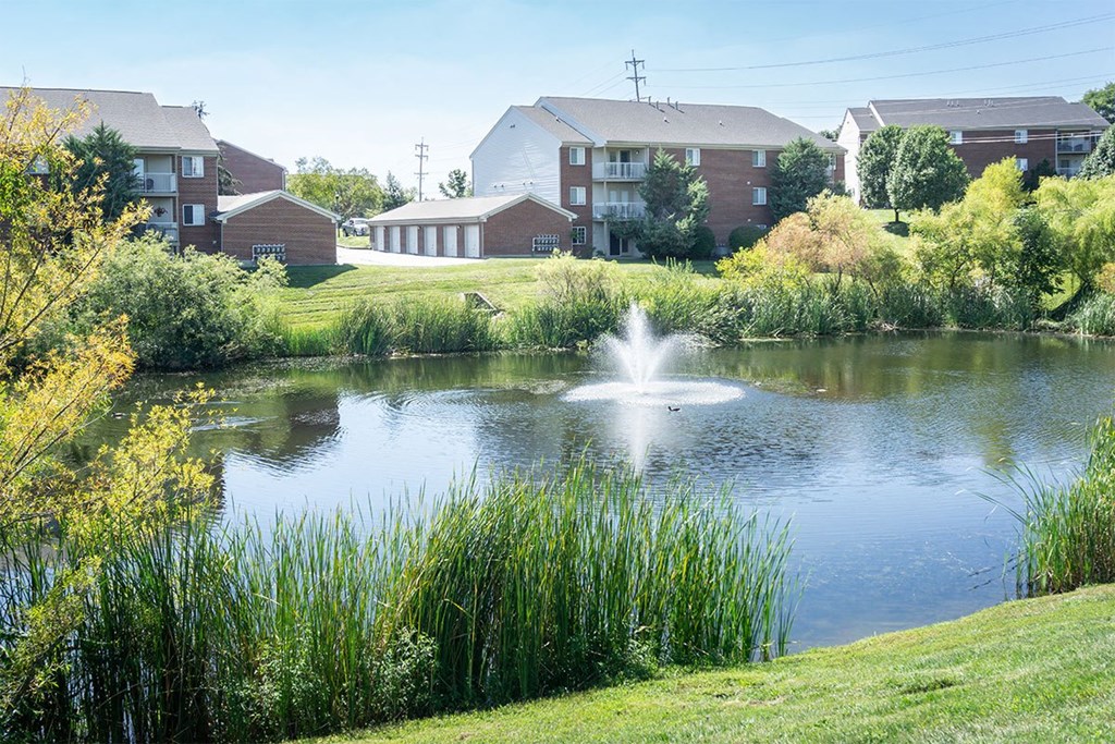 A pond with a fountain in the middle of it.