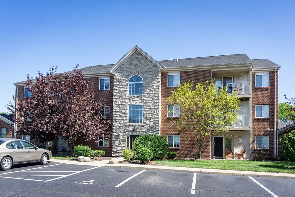 A brick building with a car parked in front.
