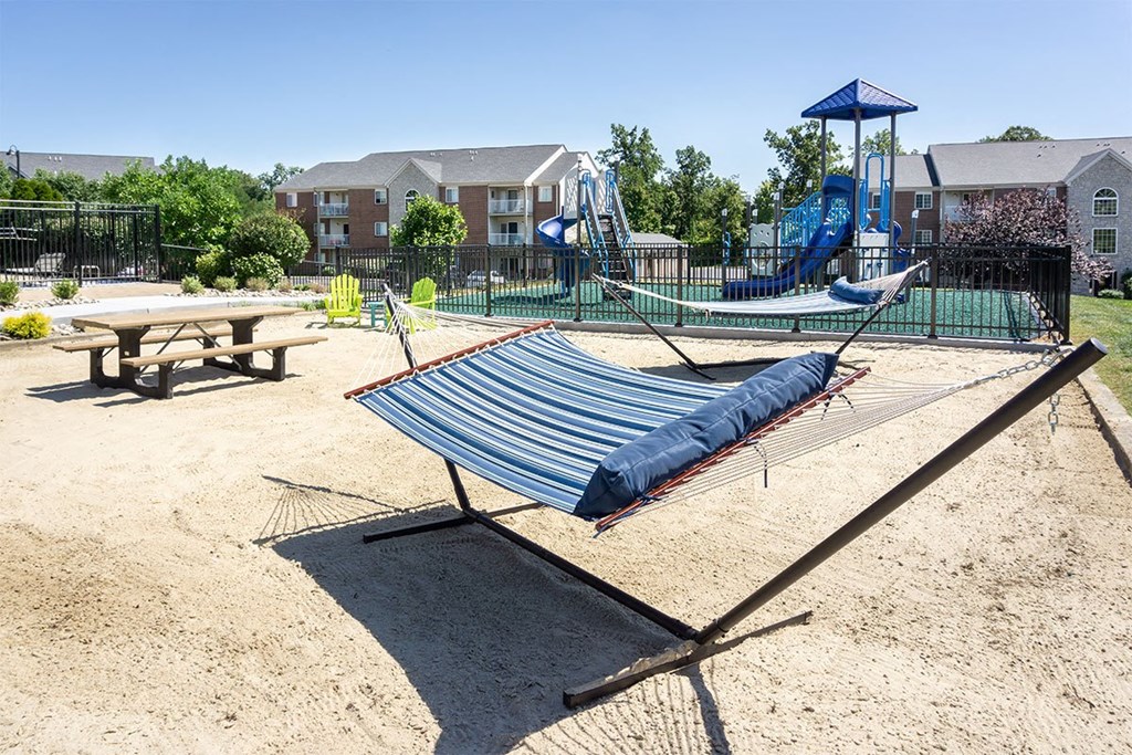 A playground with a blue tarp covering a swing set.