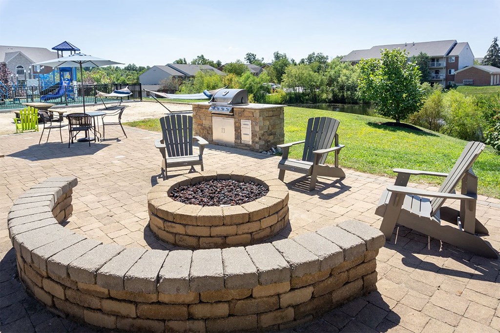 A backyard with a fire pit and chairs.