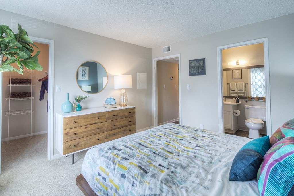 a bedroom with a bed and a bathroom with a toilet