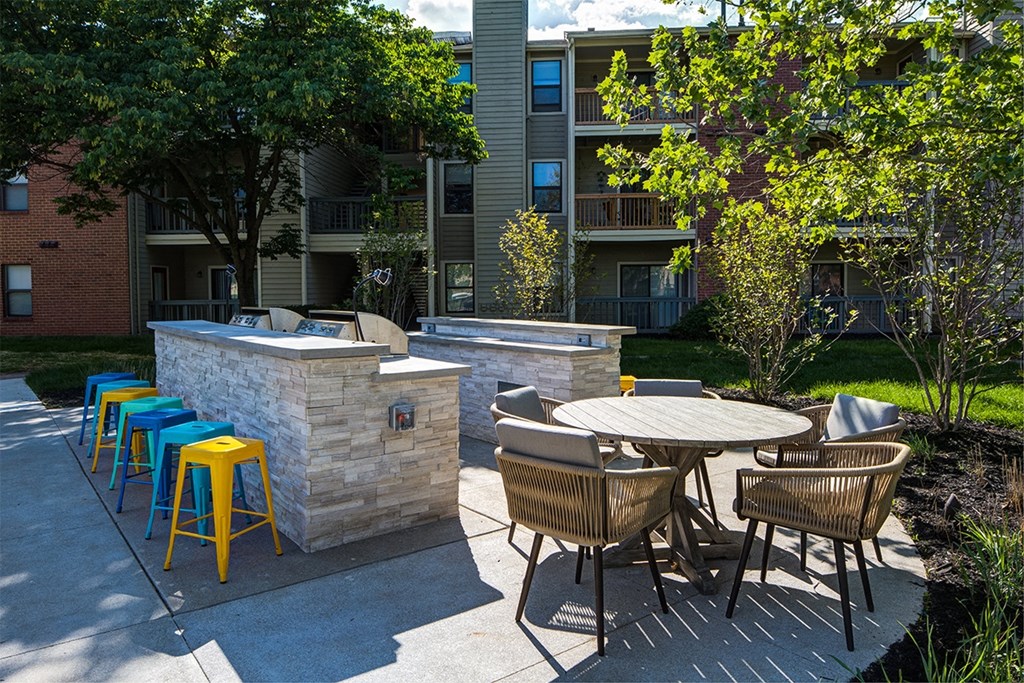 a patio with a fire pit and a table with chairs