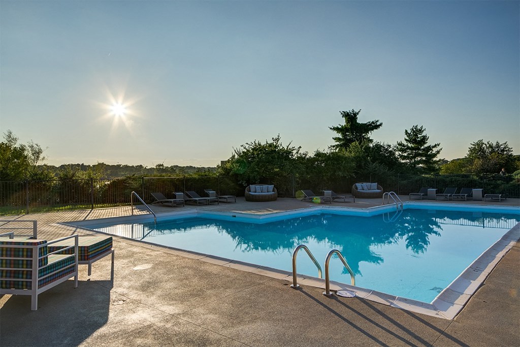 a swimming pool at a resort with the sun shining over it