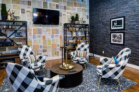 a living room with black and white checkered chairs and a television