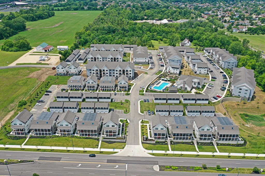 A bird's eye view of a residential area with houses and a swimming pool.